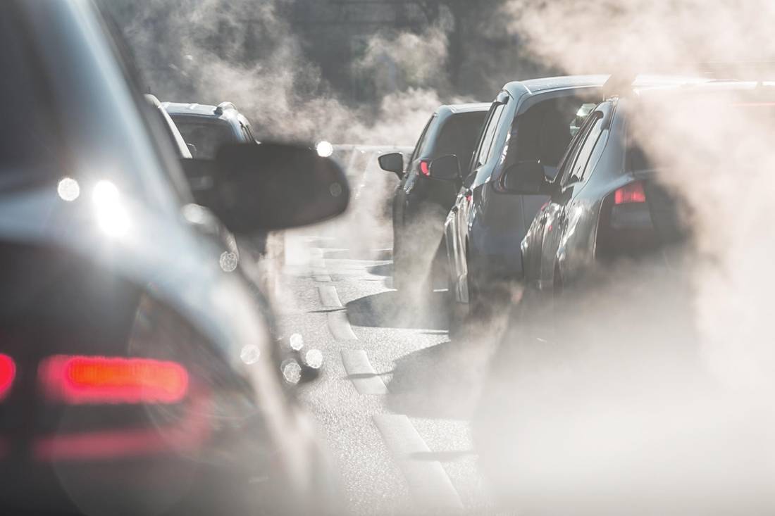 Traffic jam. Blurred silhouettes of cars surrounded by steam from the exhaust pipes. fog