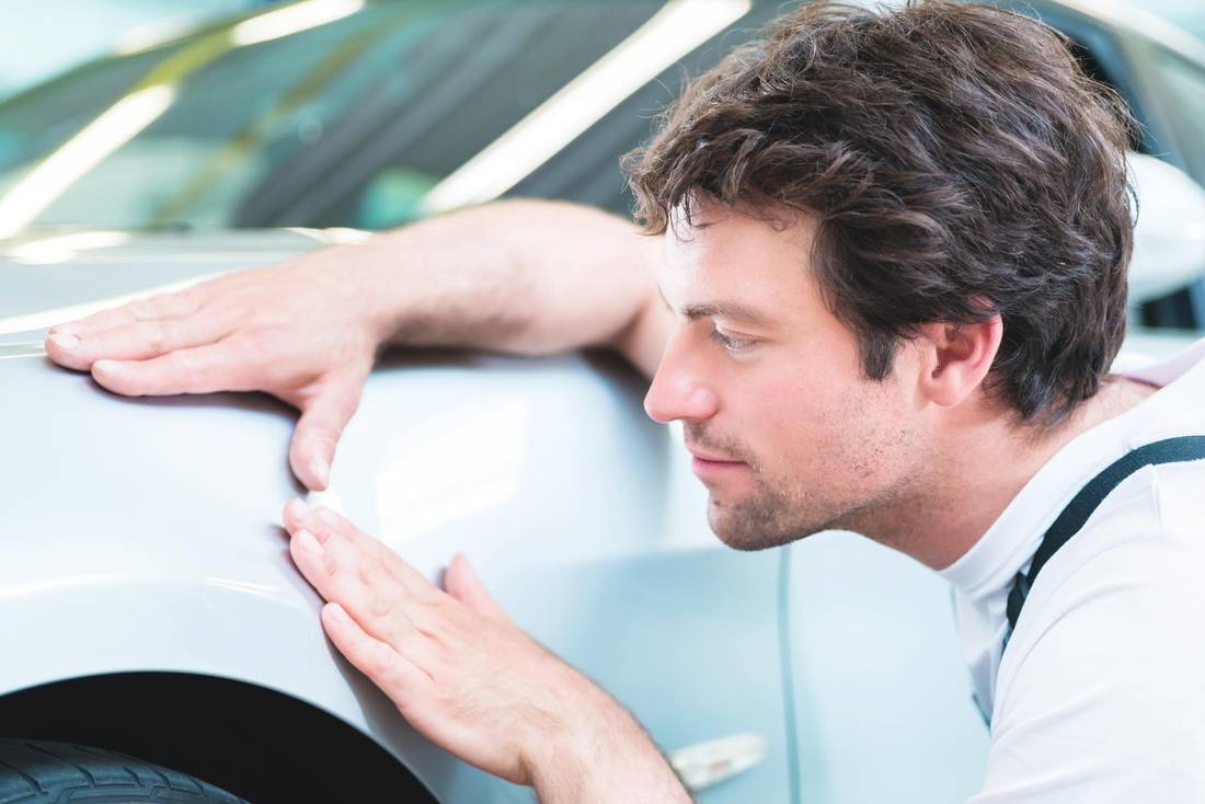 man checking the car, car repair dents TÜV